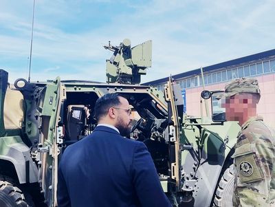 Alexandre Benalla con un oficial del ejército estadounidense ante vehículos militares
